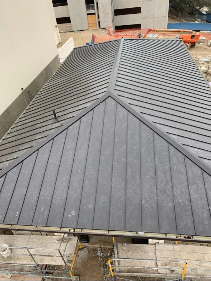 Commercial metal roof construction with crane equipment in Anthony